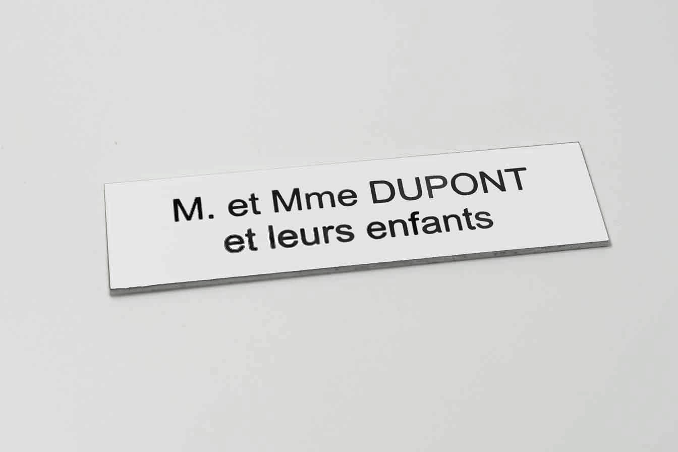 Plaque de boîte aux lettres en plastique blanc avec texte noir gravé