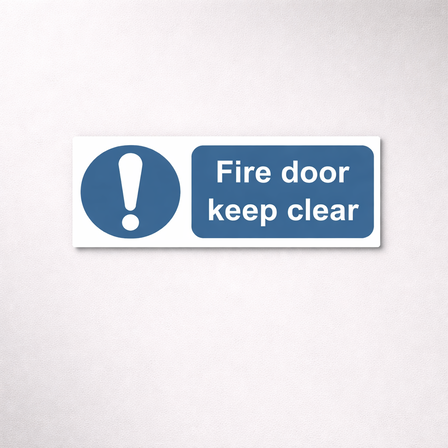 Fire exit door sign in vinyl, 450 × 150 mm, shown with the example text “Fire door keep clear”.