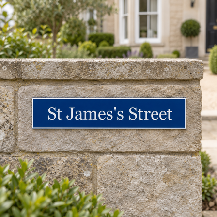 Blue engraved sign mounted on brick