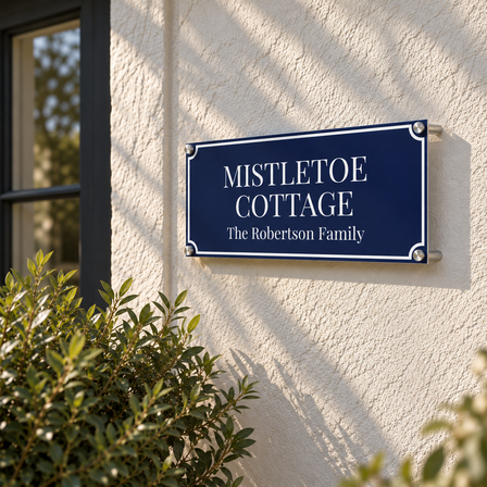 Navy aluminium house sign reading Mistletoe Cottage mounted with wall standoffs on a rendered cottage wall