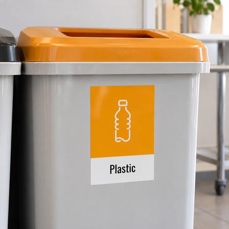 Plastic recycling decal on a grey recycling bin with an orange lid