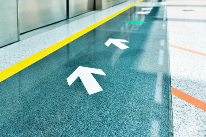 White floor decal showing a directional arrow