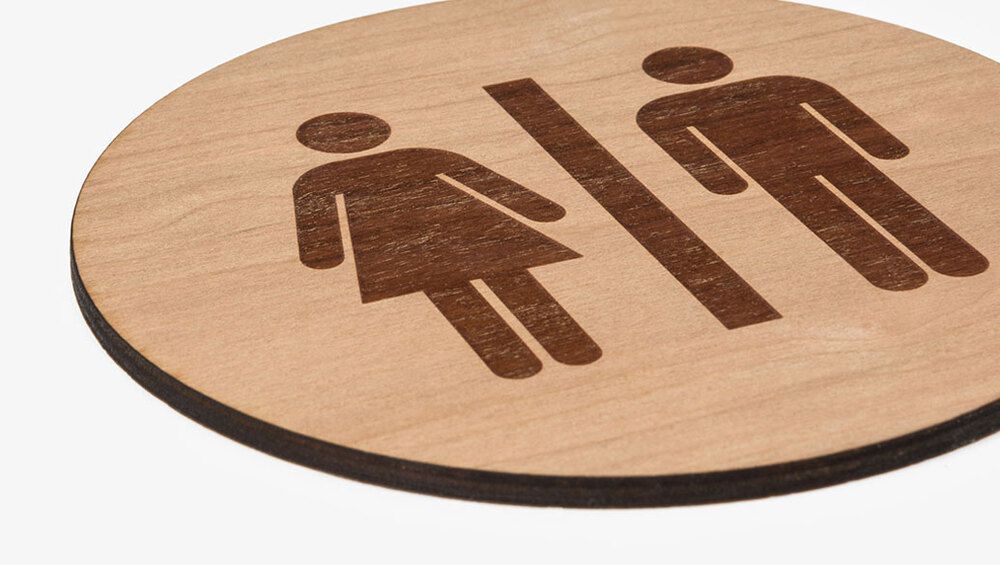 Rund träskylt med motiv i form av en WC-symbol