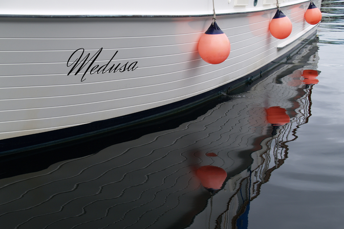 Boat sign with cut-out vinyl letters attached to the boat