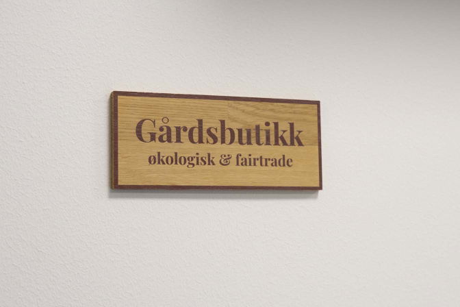 Gårdssskilt i tre med teksten gårdsbutikk