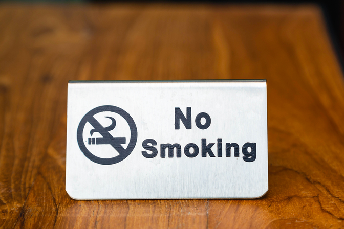 „Rauchen verboten“-Schild mit durchgestrichenem Symbol