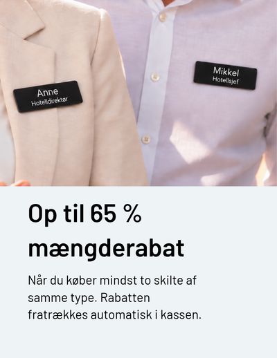 To hotelmedarbejdere med sorte navneskilte med navn og stillingsbetegnelse på en lys blazer og en hvid skjorte.